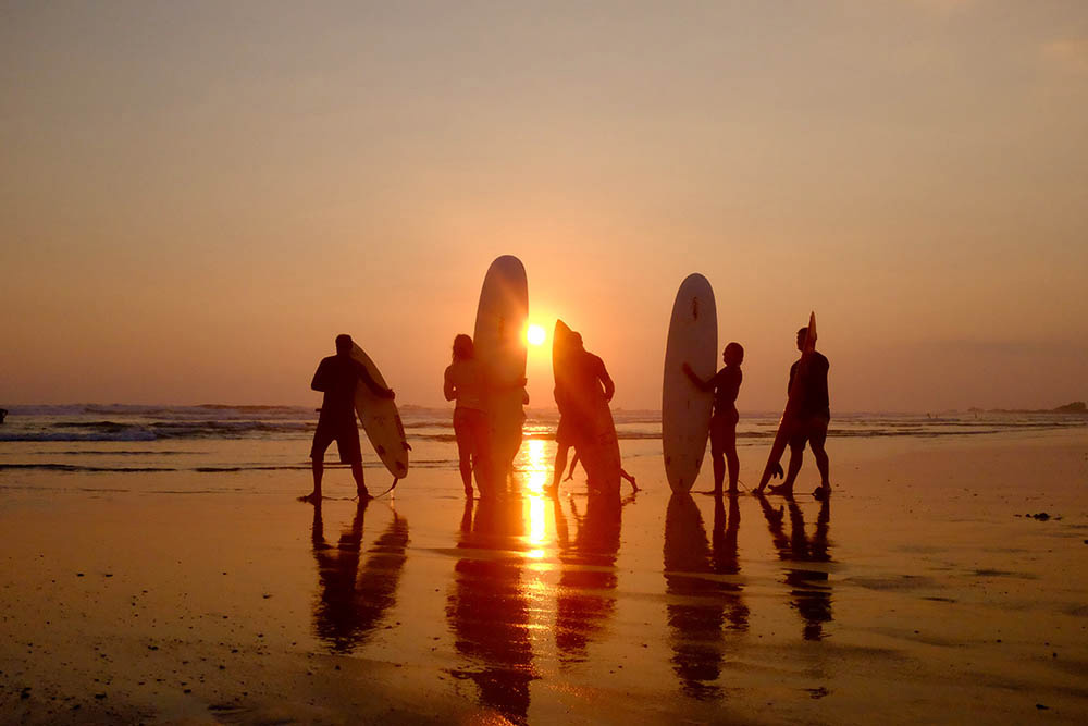 Surfers at Playa Guiones beach in Nosara, Costa Rica, by Andrew Day.
