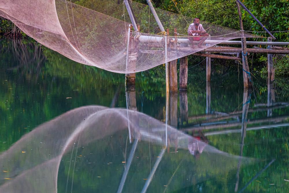 Tim Bird photographed a man sitting by a Chinese fishing net at Kochi in Kerala, India