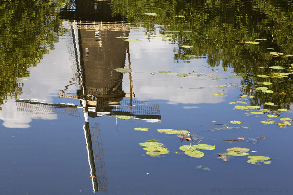 A windmill (De Walvisch) reflects in the water of a canal in Schiedam, the Netherlands.