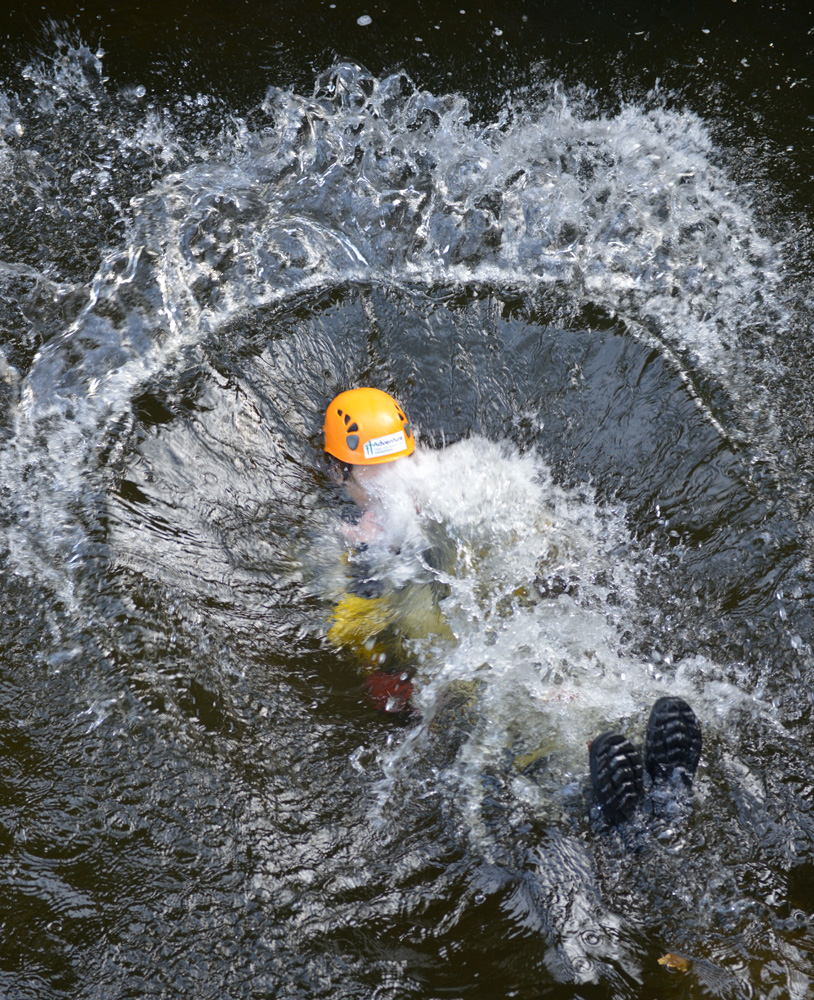 Person makes a splash during a Gorge Walking adventure in local Snowdonia mountain streams around Betws y Coed in North Wales. Image is part of the British Guild of Travel Writers Online Photography Exhibition with an Adventure theme