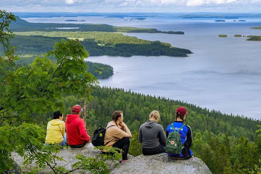 People in eastern Finland take a break from hiking along the Koli ridge to enjoy the spectacular lakeland views near the border with Russia